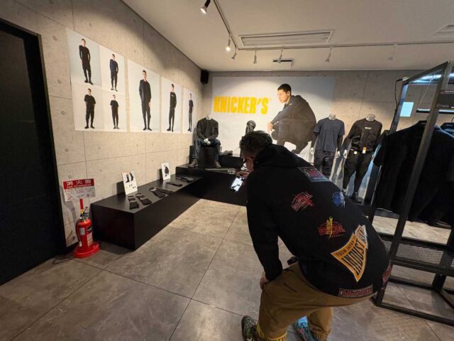 TSデザイン展示会2026SSレポート_熱心に商品写真を撮る澤田店長2