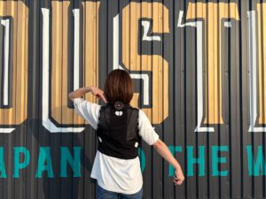 バートル2025ペルチェベストを着用しホールを指さしている