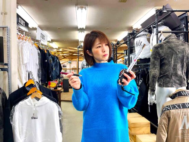 ダイマツ店舗_左手用スケールとペンを持って困惑している谷